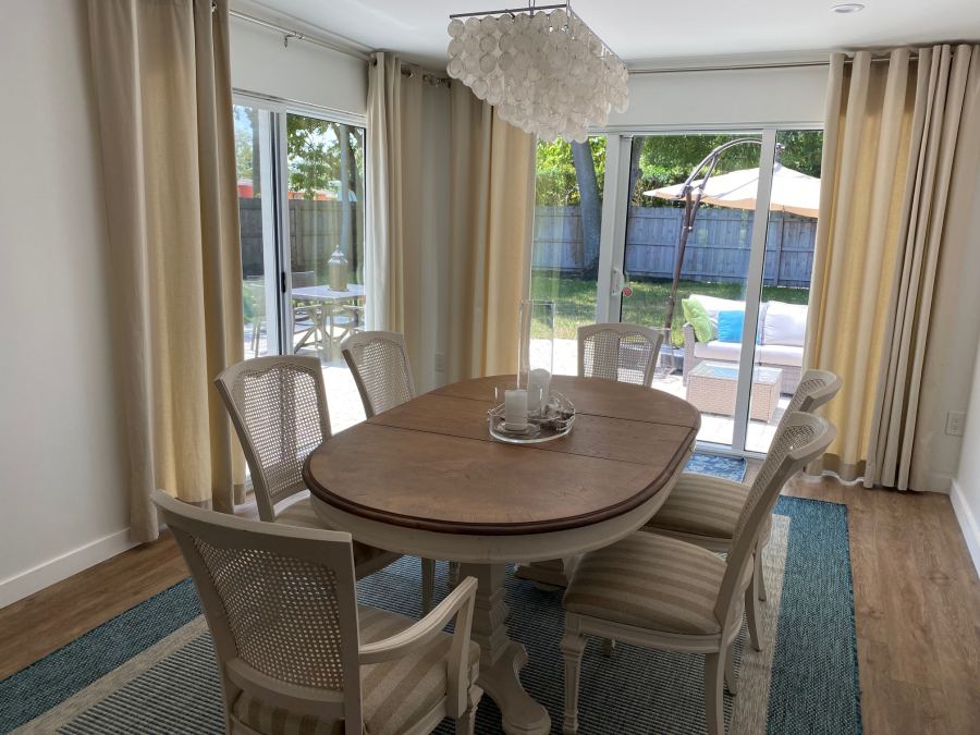 Dining table and chairs in a bright room with sliding doors to a garden