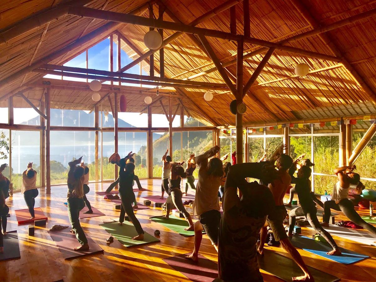 A class in Warrior II, facing the lake.