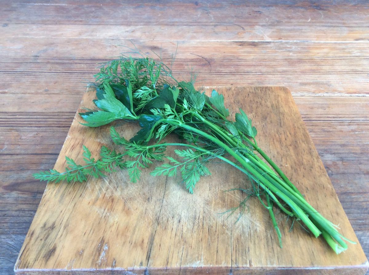 Fresh green herbs on a wooden board.