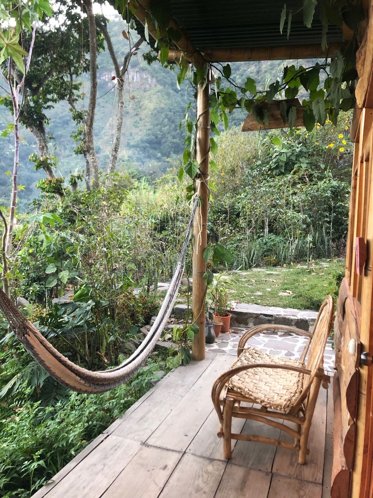 A hammock and a chair on a quiet porch.