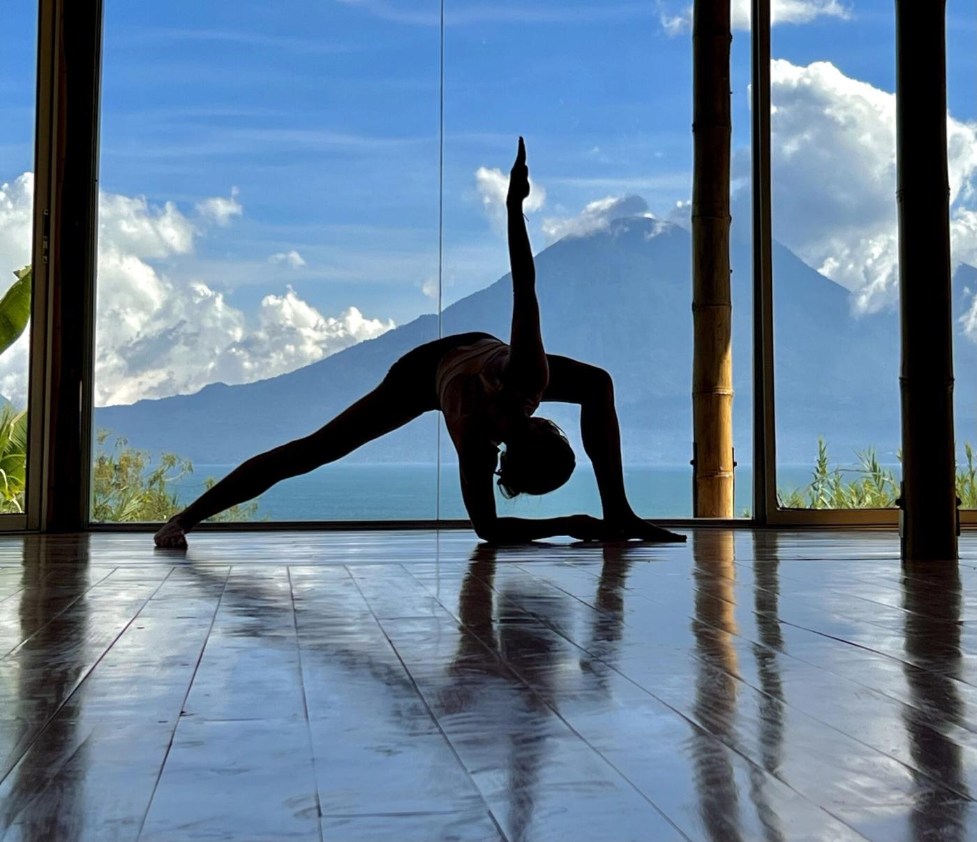A side stretch in silhouette, volcano and lake behind