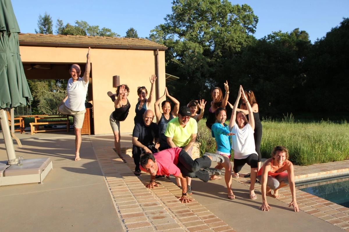 An outdoor yoga class with the lake and volcano behind.