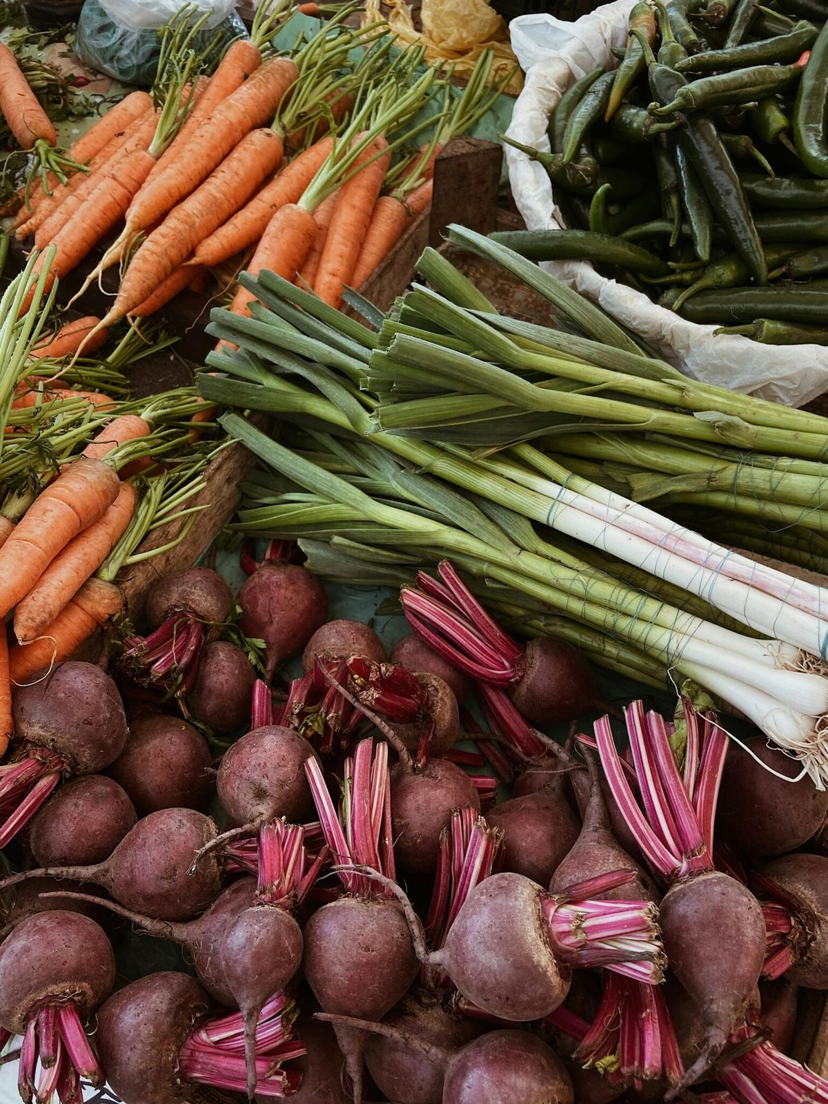 Market vegetables, including leafy greens, carrots, and beets.