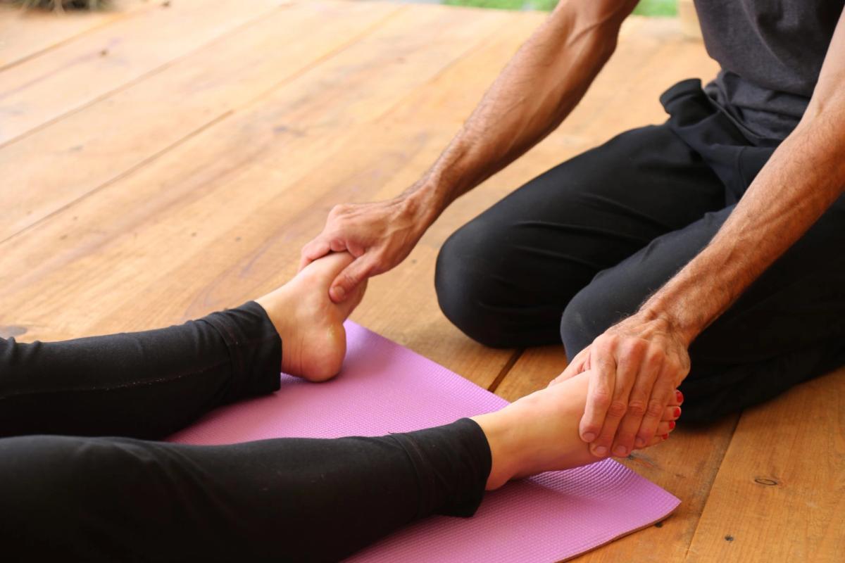 A teacher holding a student’s feet during an assist