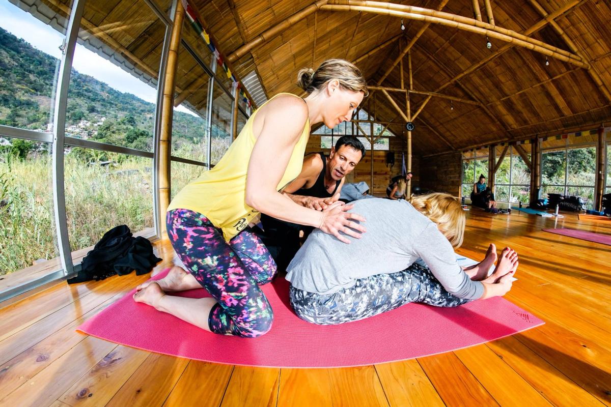 A hands-on assist in a head-to-knee fold.