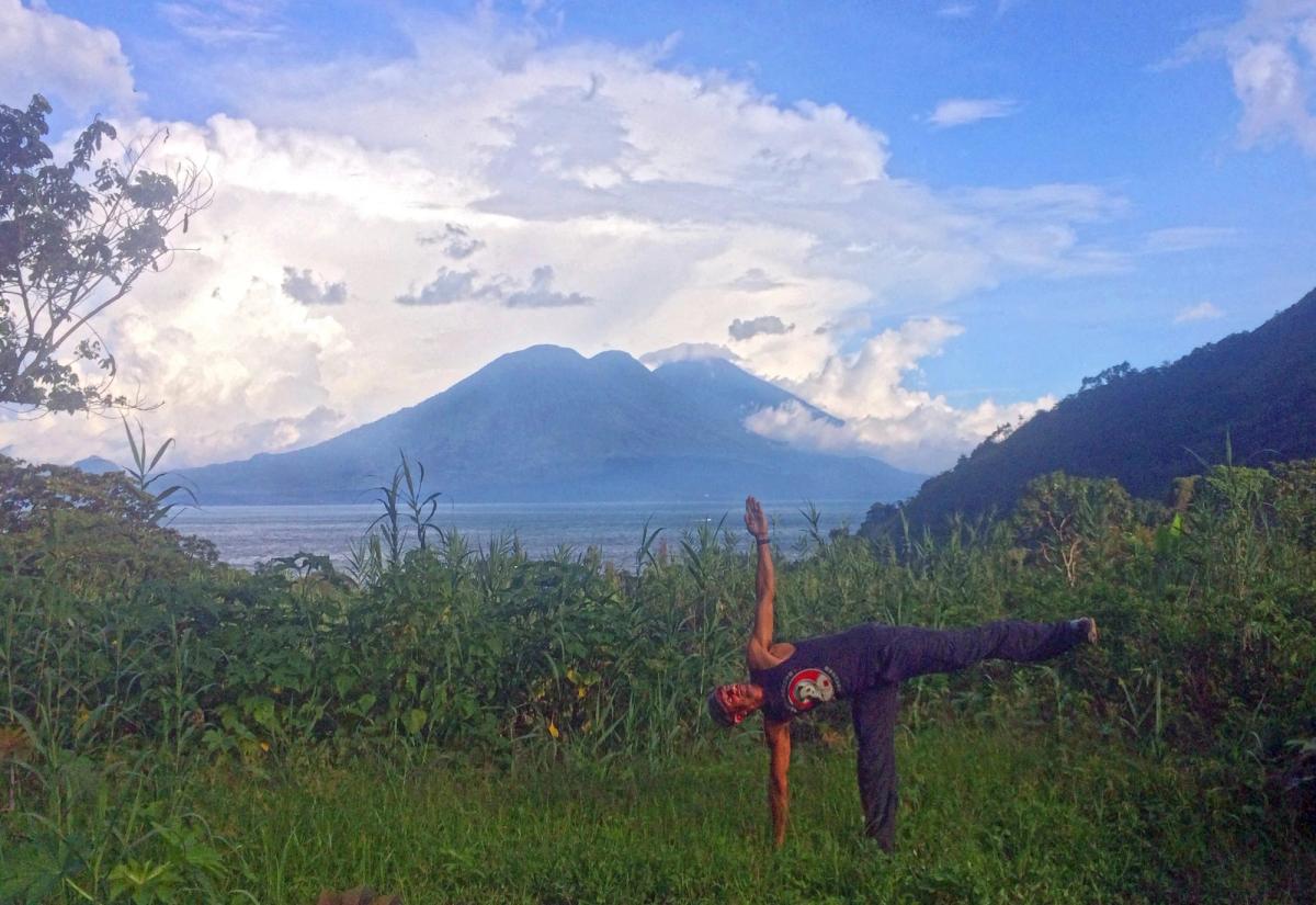 Warrior II practiced outdoors with the volcano behind.