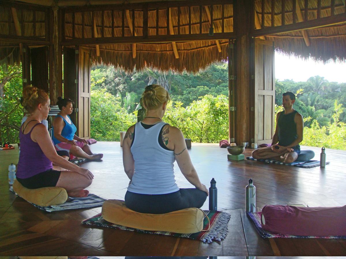 Easy pose, hands on the knees, in the shala.