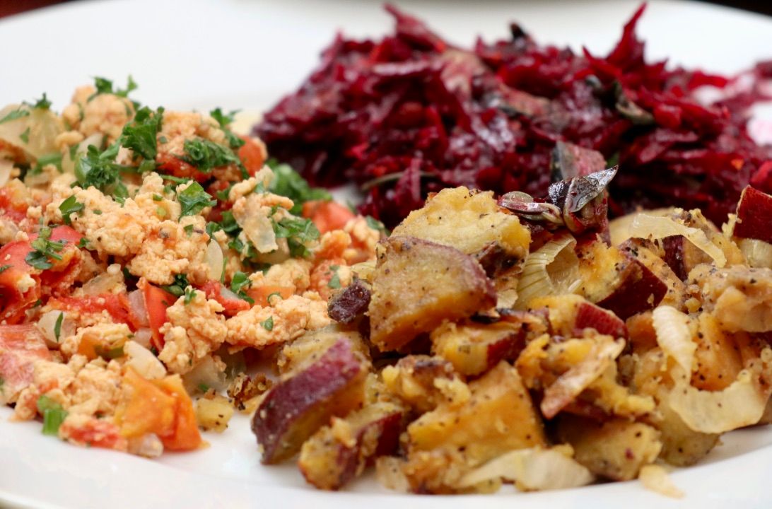 A bowl of grains with roasted beets and greens.