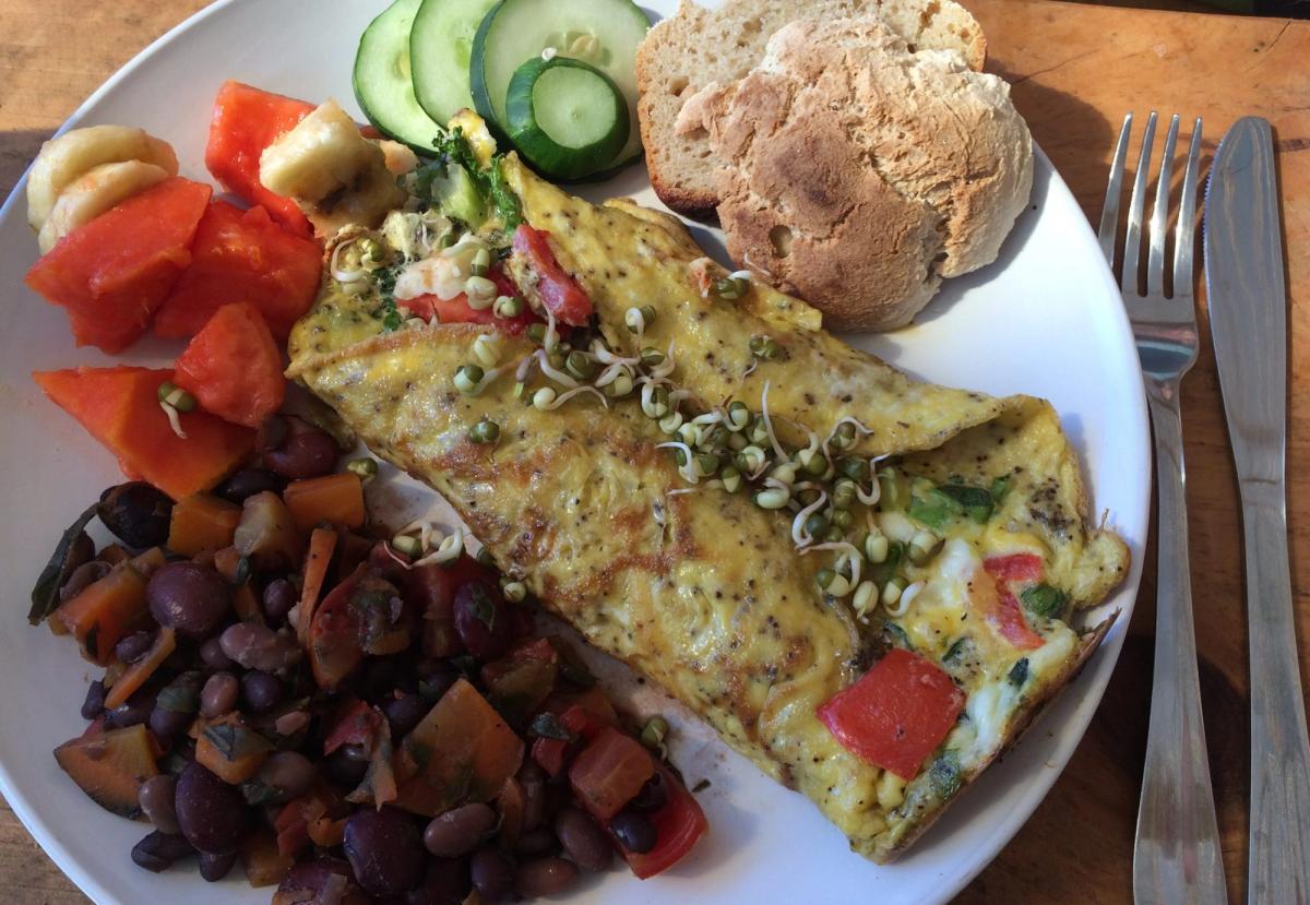 A plate with eggs, beans, and vegetables.