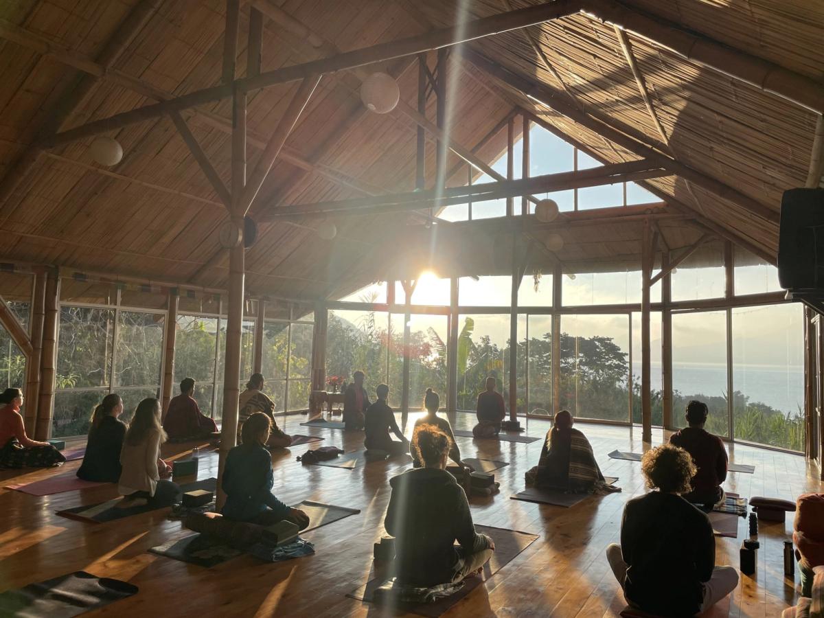 A class seated in meditation at sunrise.