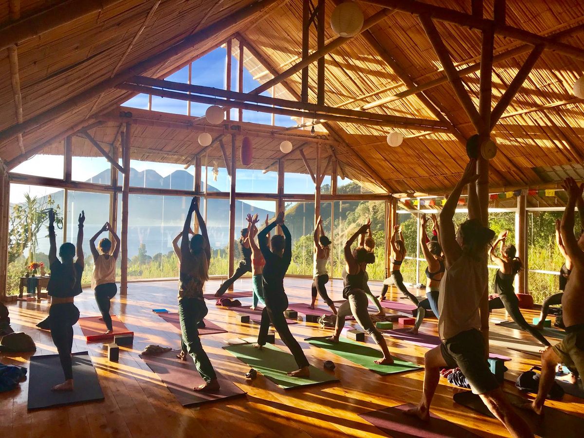 A class practicing in a wooden shala.
