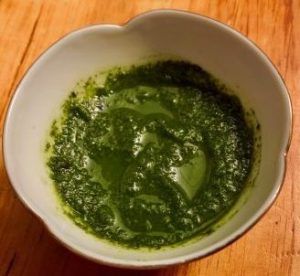 A bowl of green herb sauce.