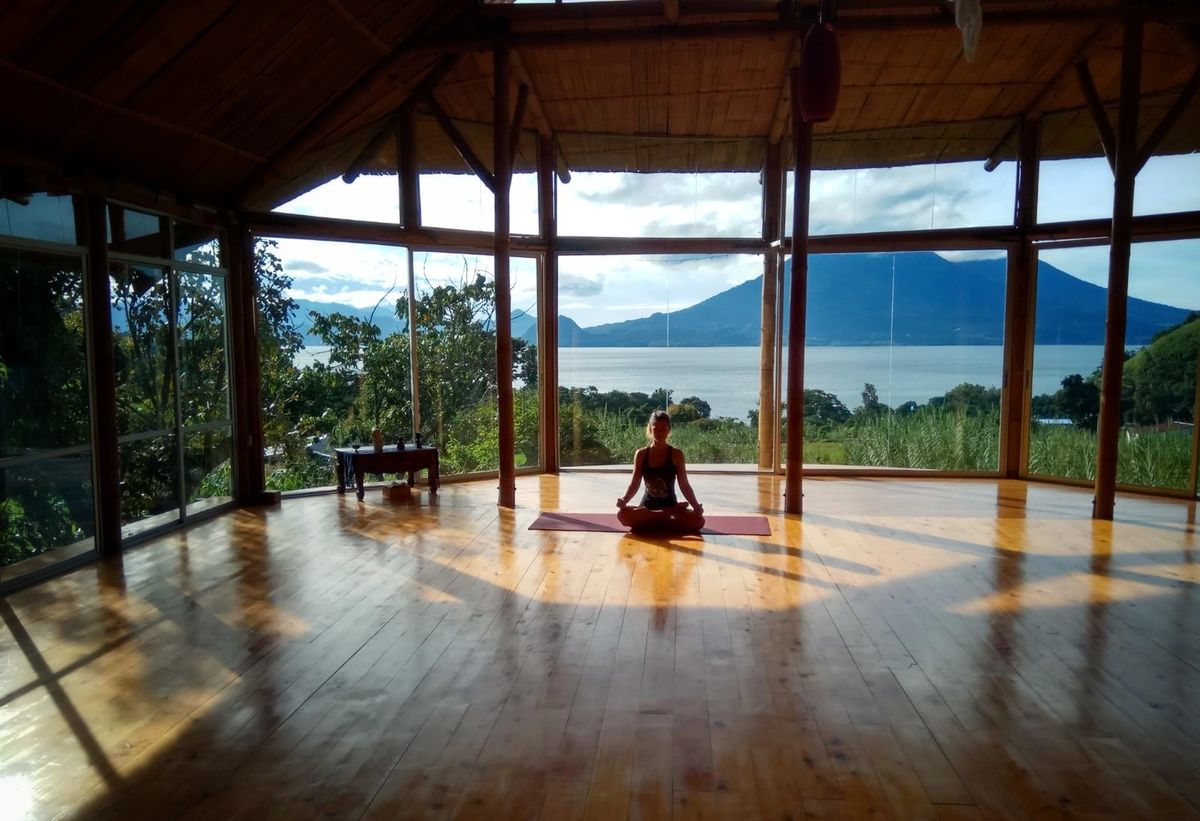 One person seated in meditation in an empty round shala.