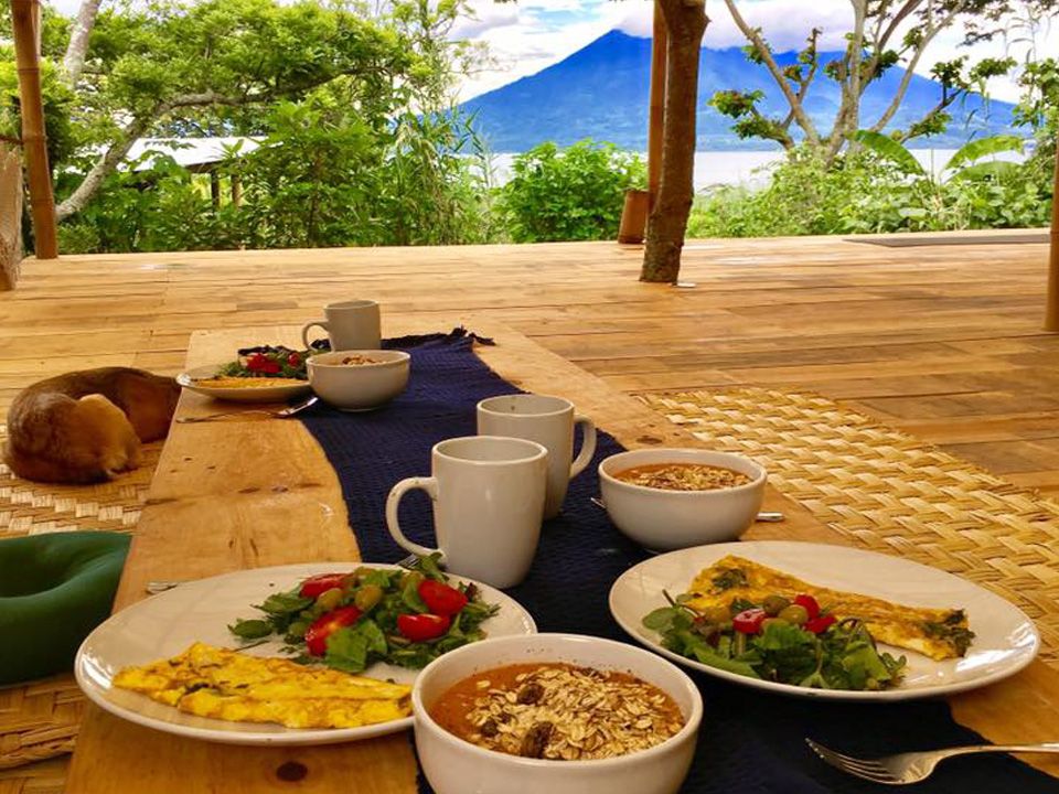 A breakfast spread of eggs, fruit, and grains outdoors.