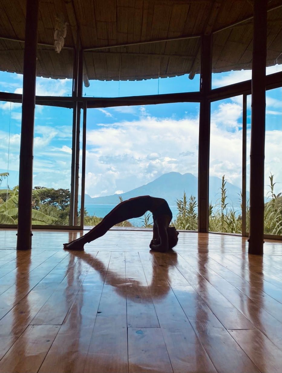 Downward-facing dog in the shala, lake and volcano behind.