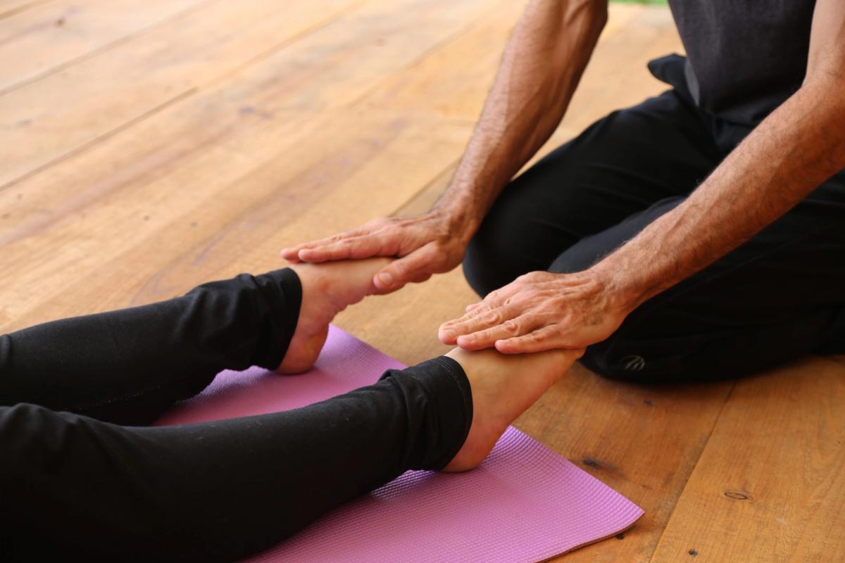 A seated forward fold with hands holding the feet.