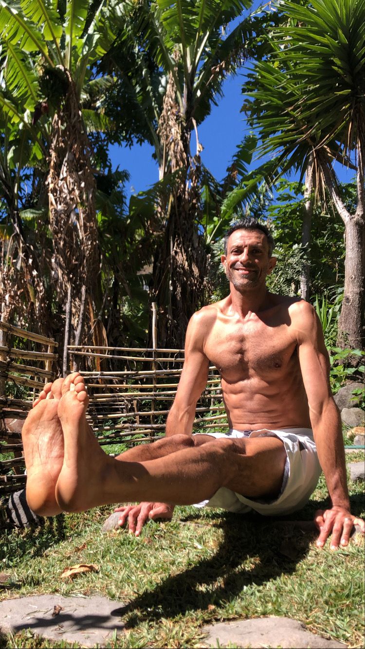 Doron seated in a squat outdoors.