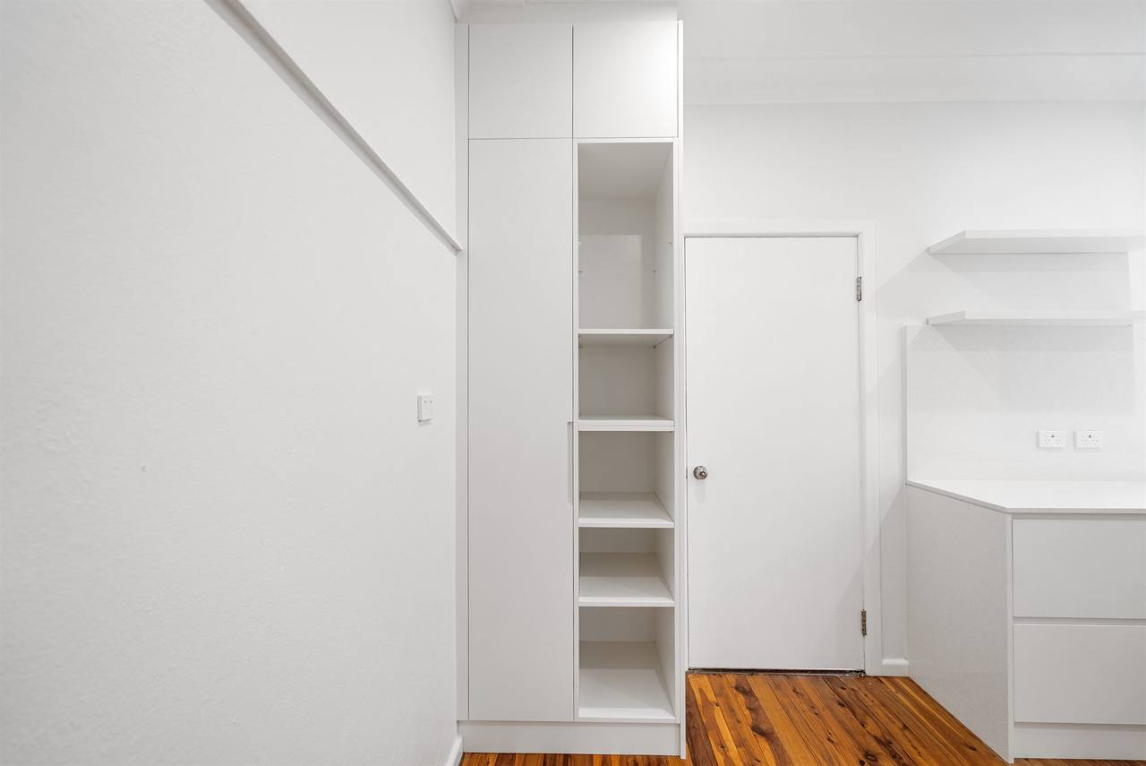 Floor-to-ceiling white pantry tower with adjustable shelving in Berala renovation