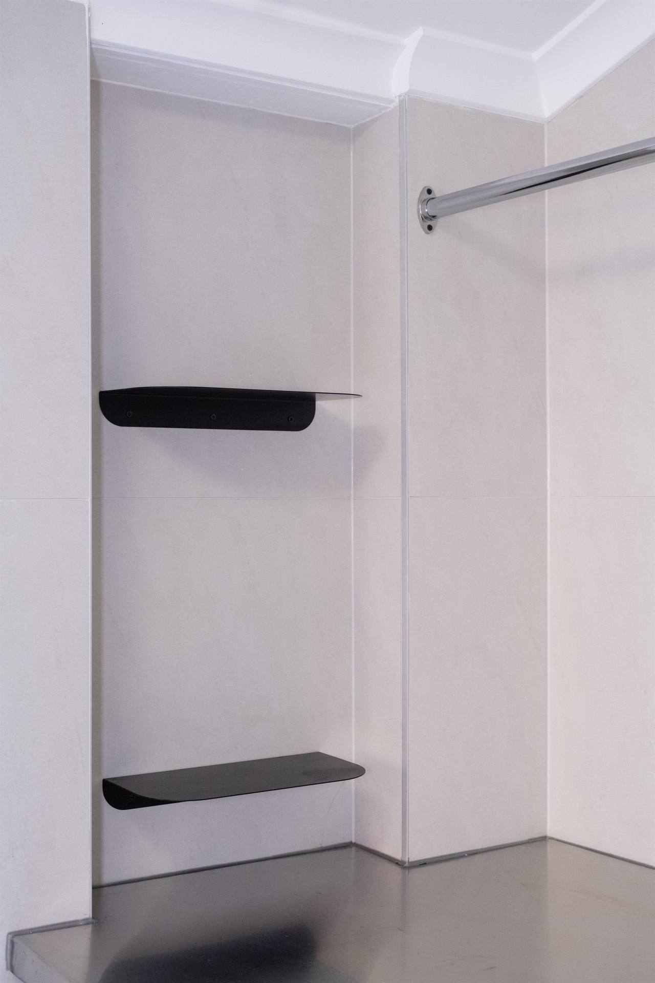 Niche detail with matte-black accessories on stone wall tile