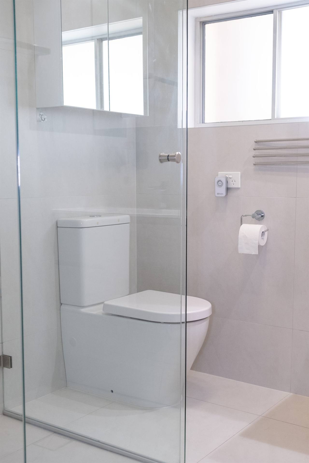 Bexley bathroom — large-format white wall tile with shower glass and toilet