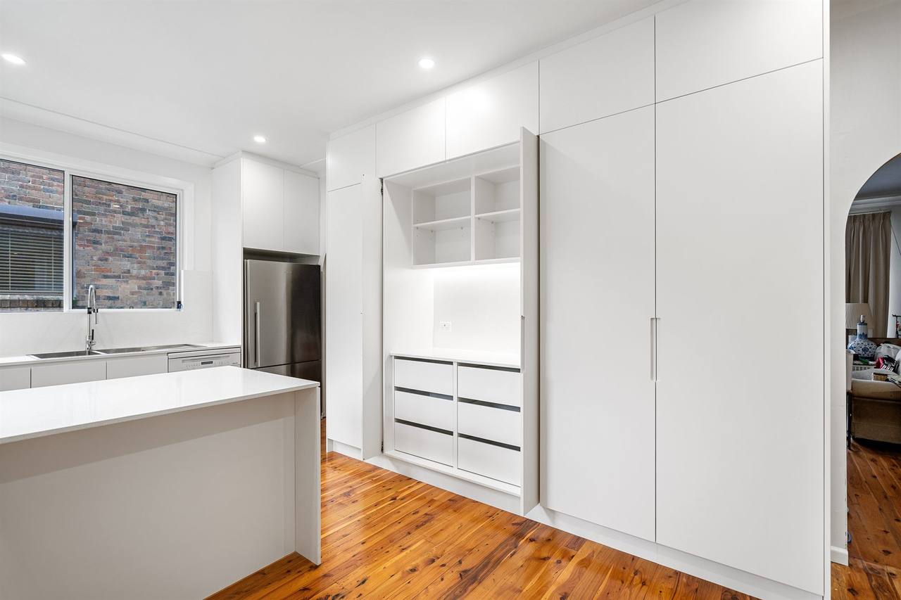 Berala kitchen — stainless fridge alongside white cabinetry on recycled blackbutt floor