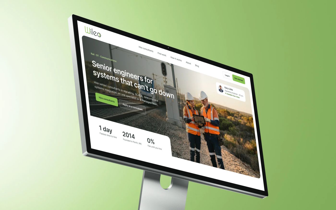 The Wileo homepage on a Studio Display: two engineers in hi-vis vests beside a rail line, the headline 'Senior engineers for systems that can't go down', buttons to hire consultants or apply, and a card showing an available signalling engineer