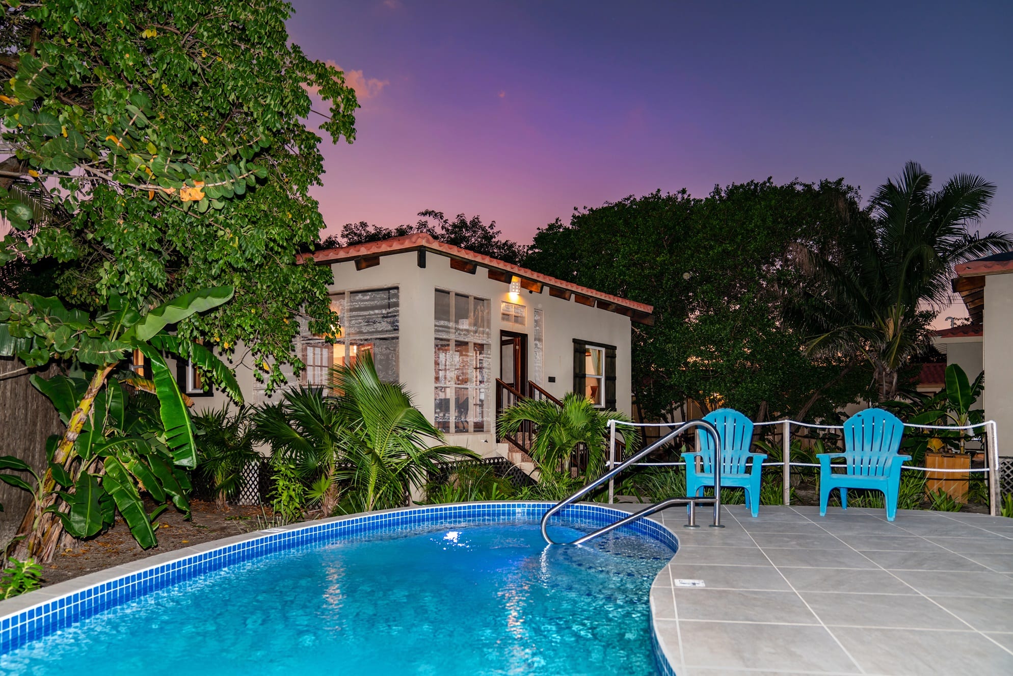 Small casita with a swimming pool and blue chairs at dusk