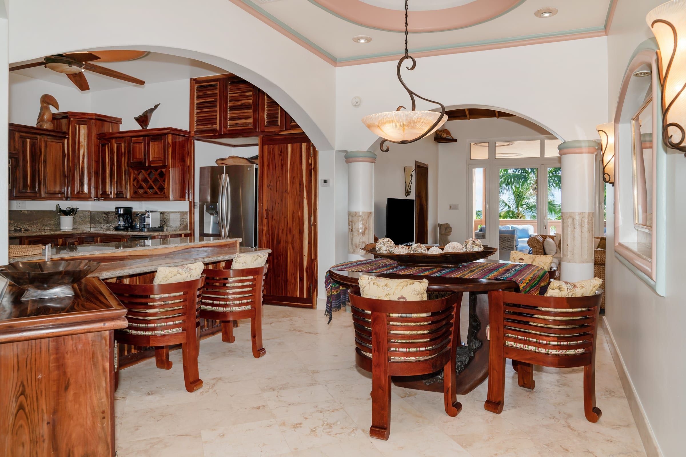 Dining table and kitchen counter under an arched opening