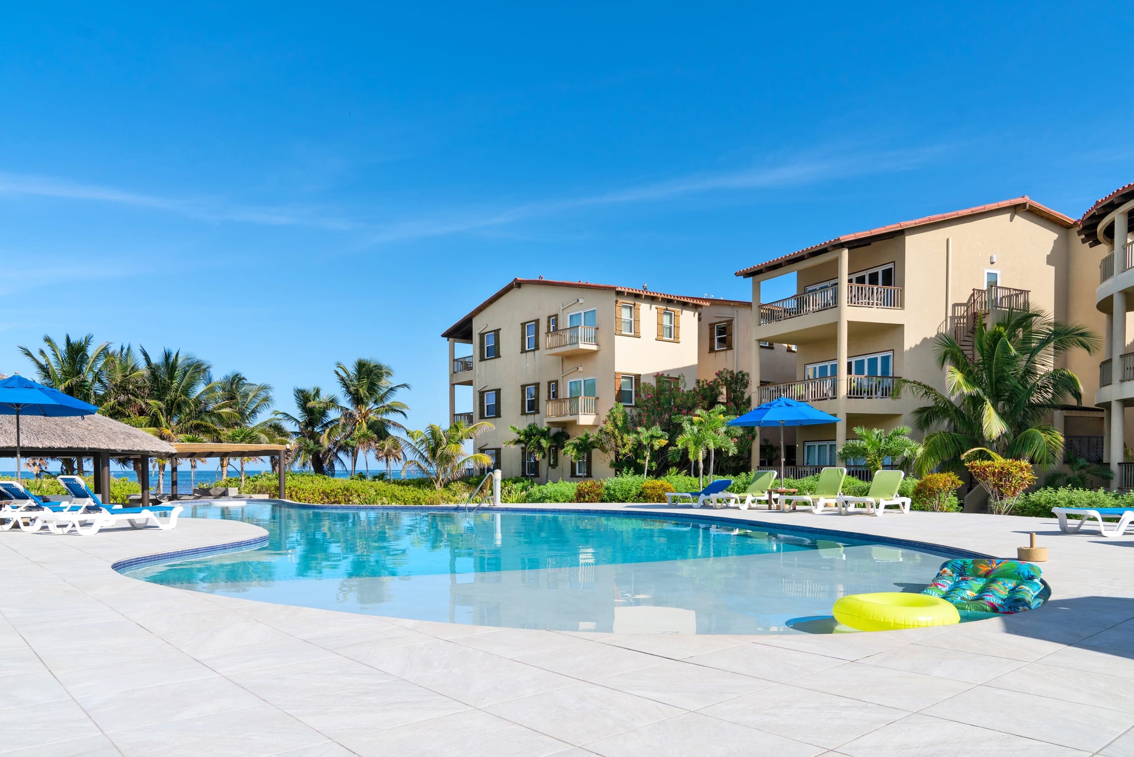 Resort pool beside a three-story oceanfront building