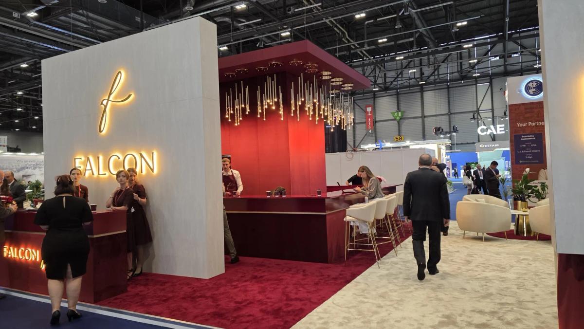 Hospitality bar and lounge area on a large aviation exhibition stand with staff serving guests