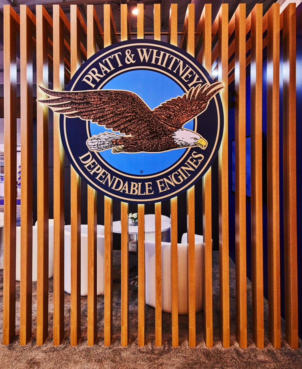 Pratt & Whitney logo wall on a custom exhibition stand with a meeting area behind