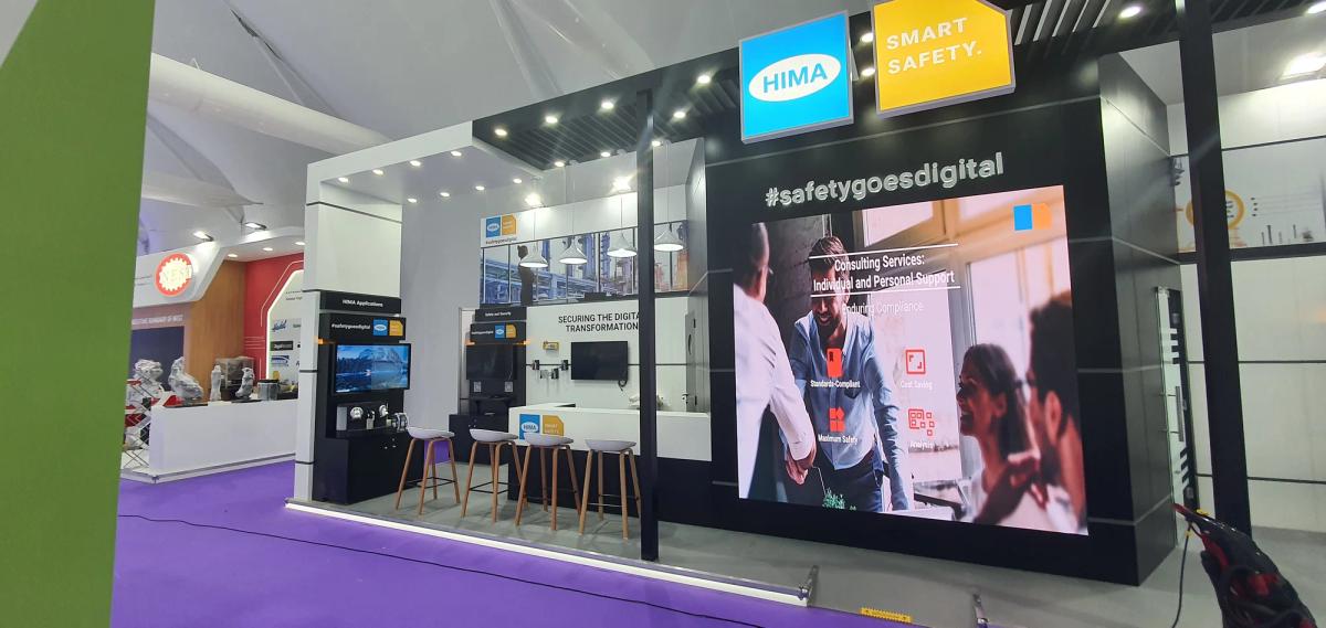 Technology exhibition stand featuring product displays, digital screens, and hospitality meeting areas