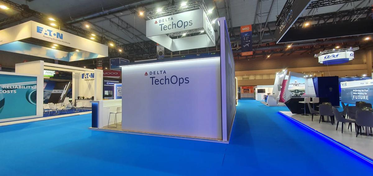 Interior view of an MRO exhibition hall showing exhibitor stands and aviation industry attendees