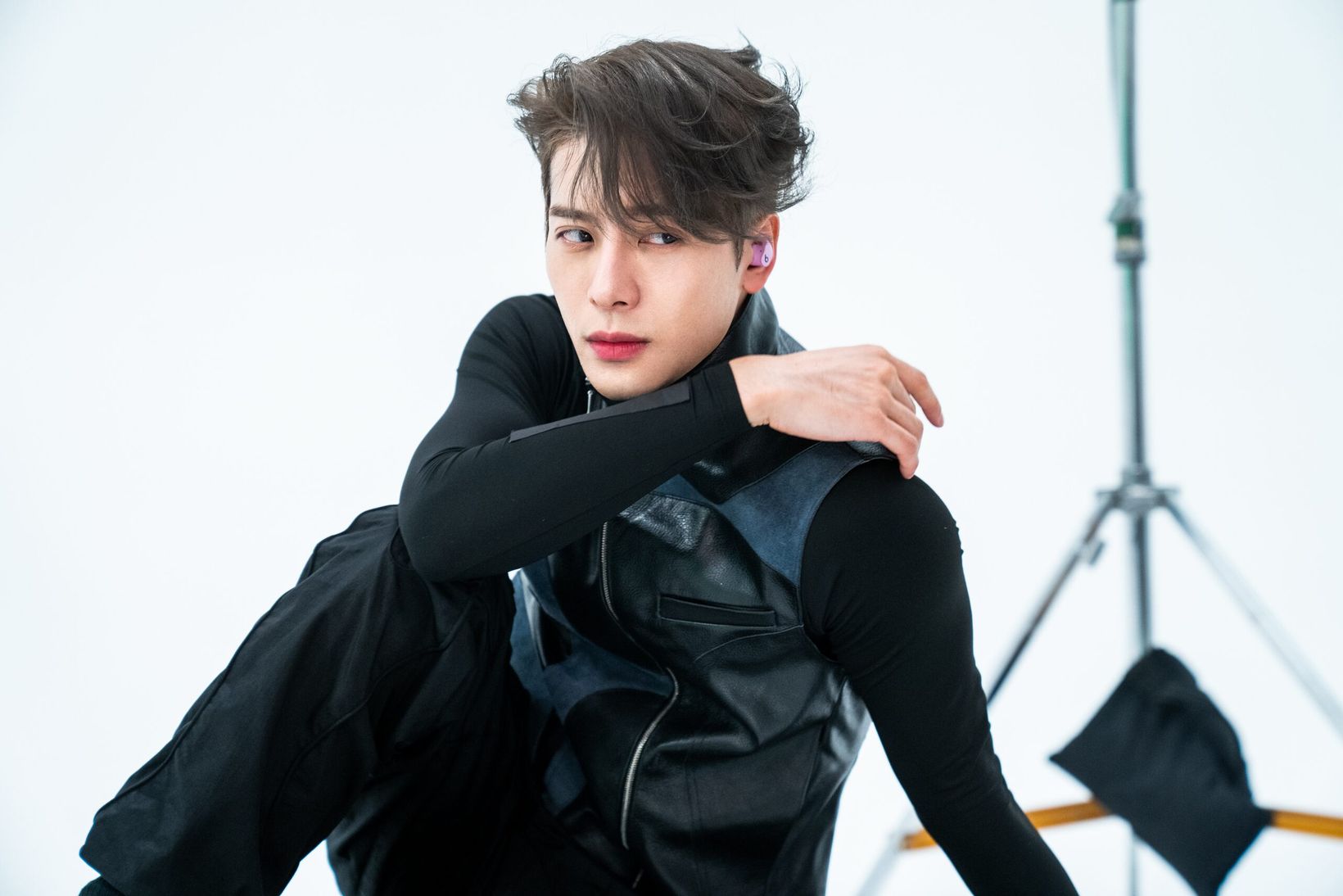 Jackson Wang posing on a white studio set during the shoot