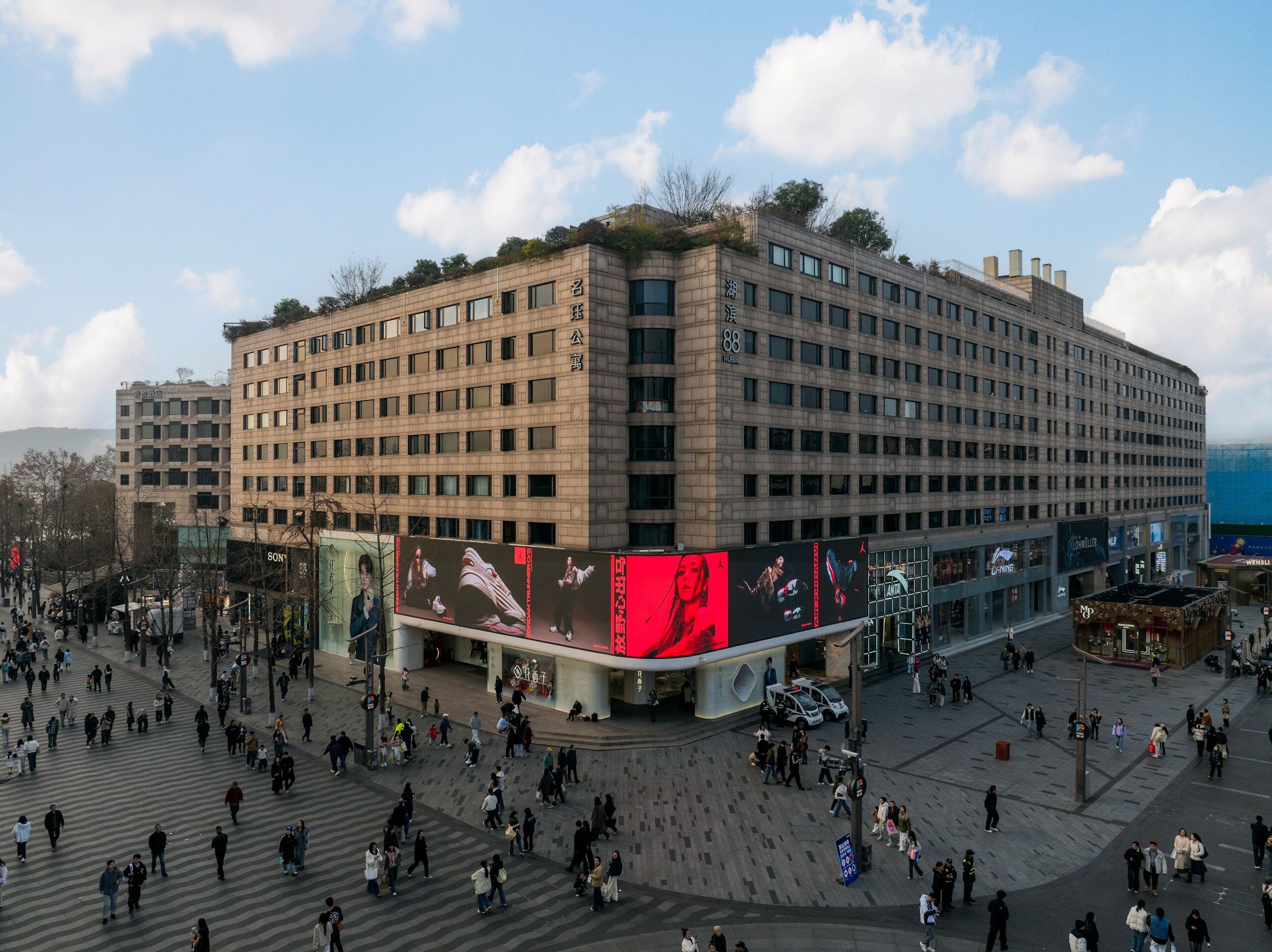 G.E.M. billboard on a building corner above a busy crossing