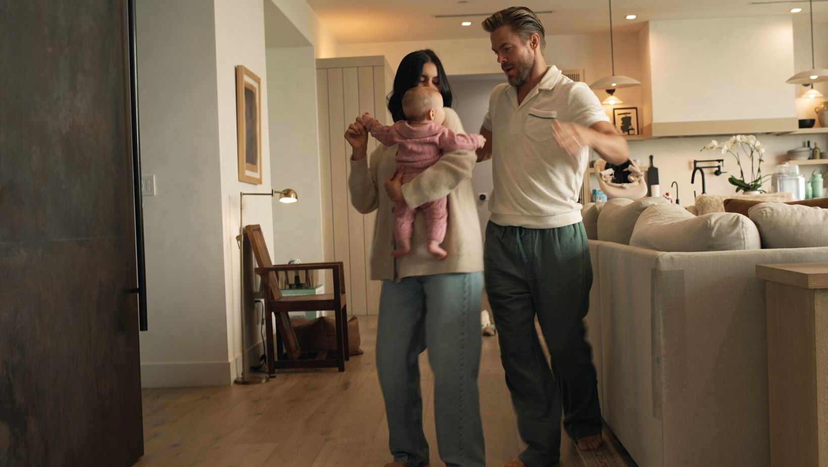 The couple walking through their living room with the baby
