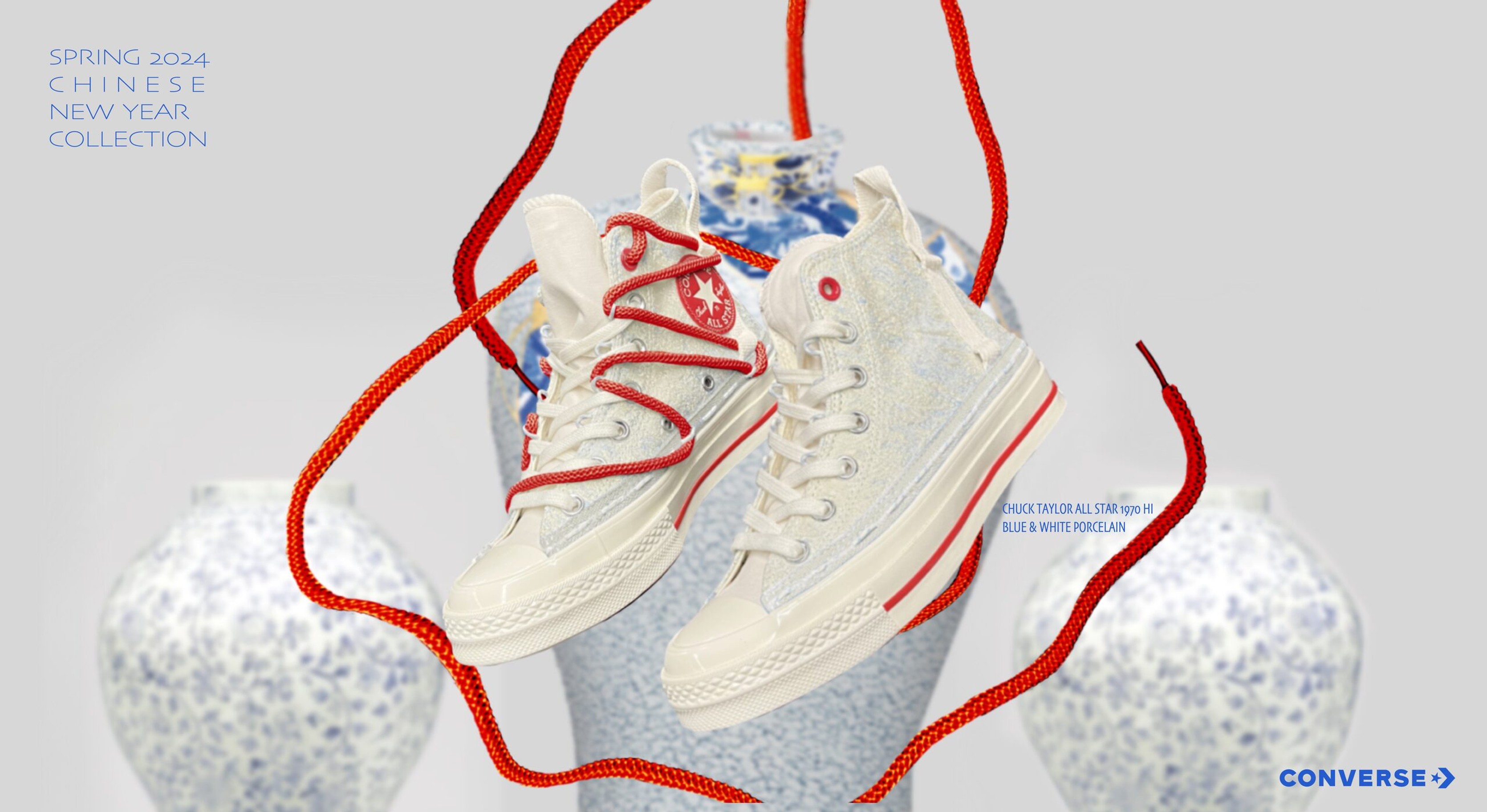 Cream Converse high-tops with blue dragon details wrapped in red laces on a porcelain vase