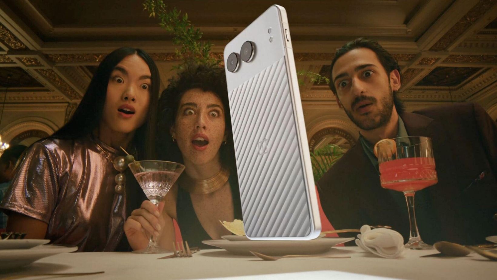 Three diners staring wide-eyed at a giant OnePlus Nord 4