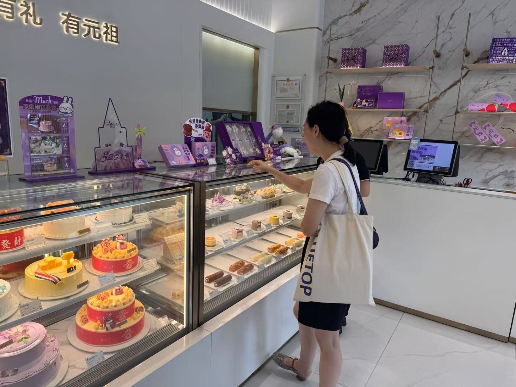 Shopper browsing the cake counter in a GANSO store