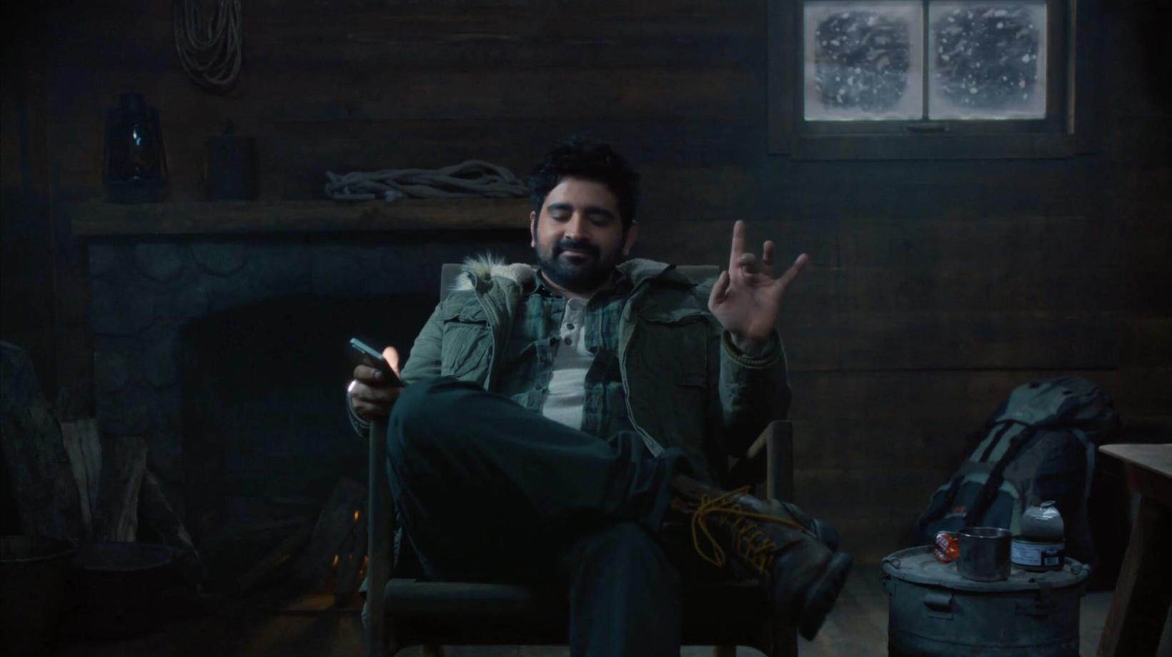 Man with a guitar relaxing in a dim wooden cabin