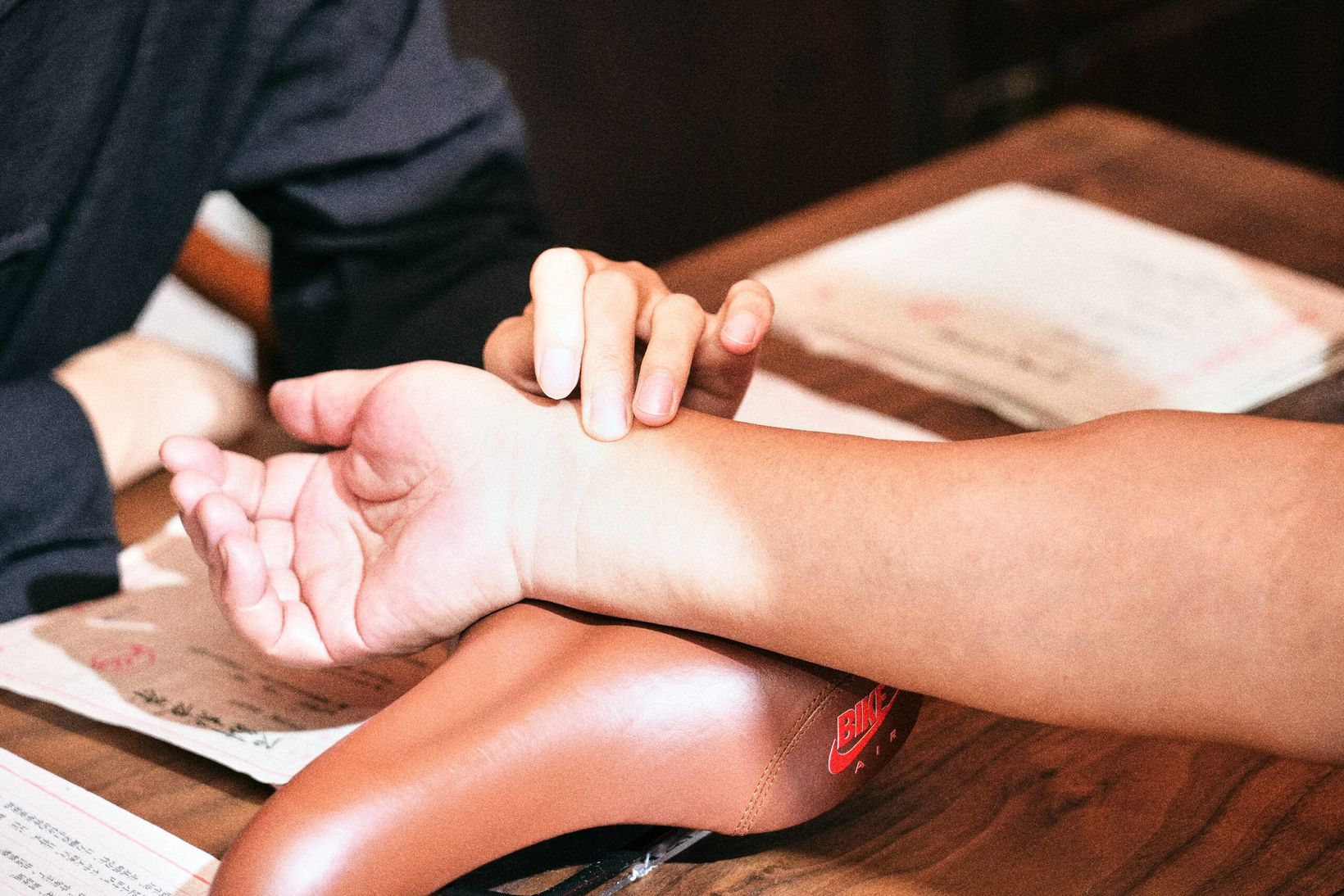 TCM doctor taking a visitor's pulse on a wooden table