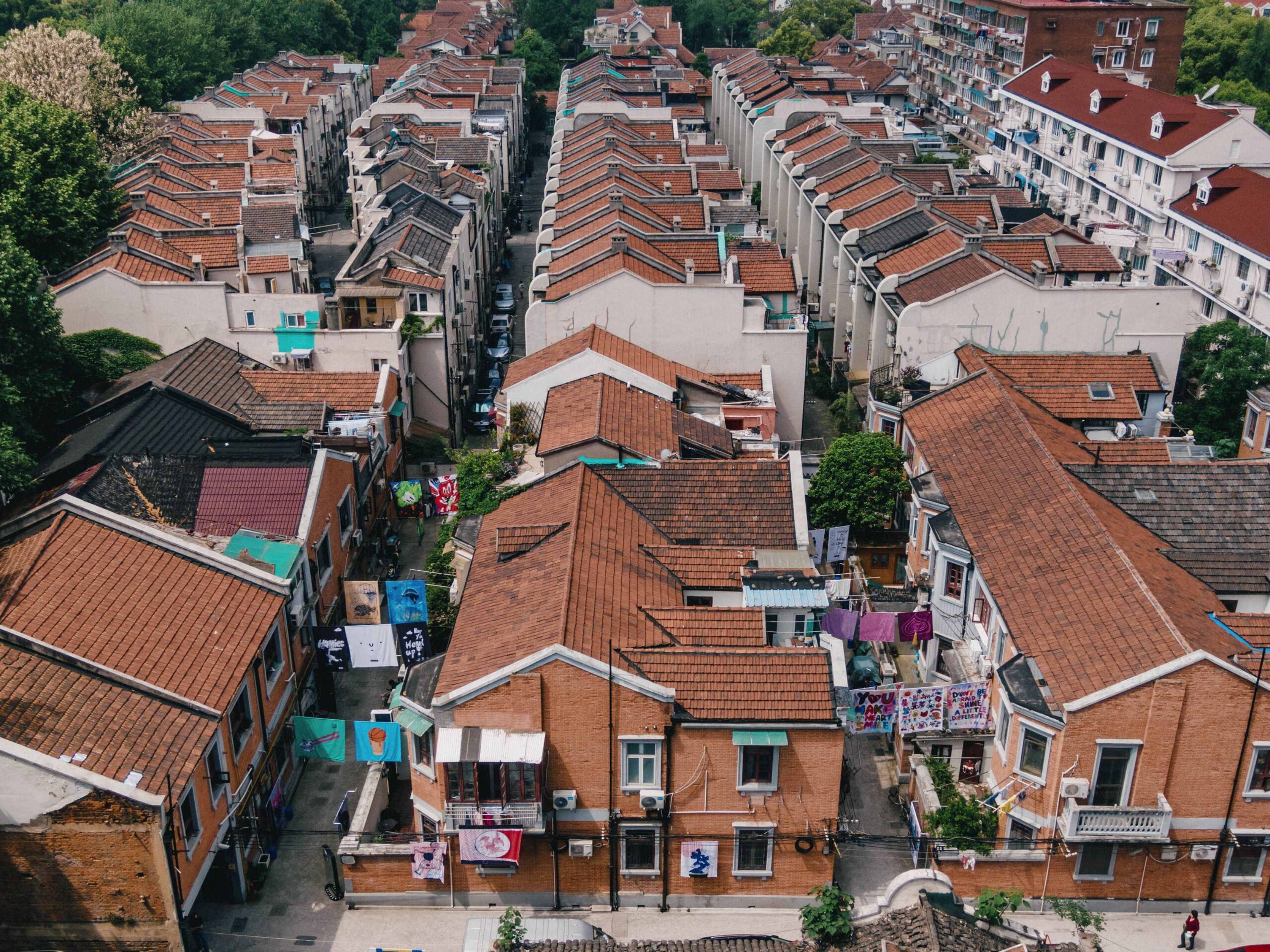 Aerial view of Shanghai longtang rooftops with artwork sheets strung between buildings
