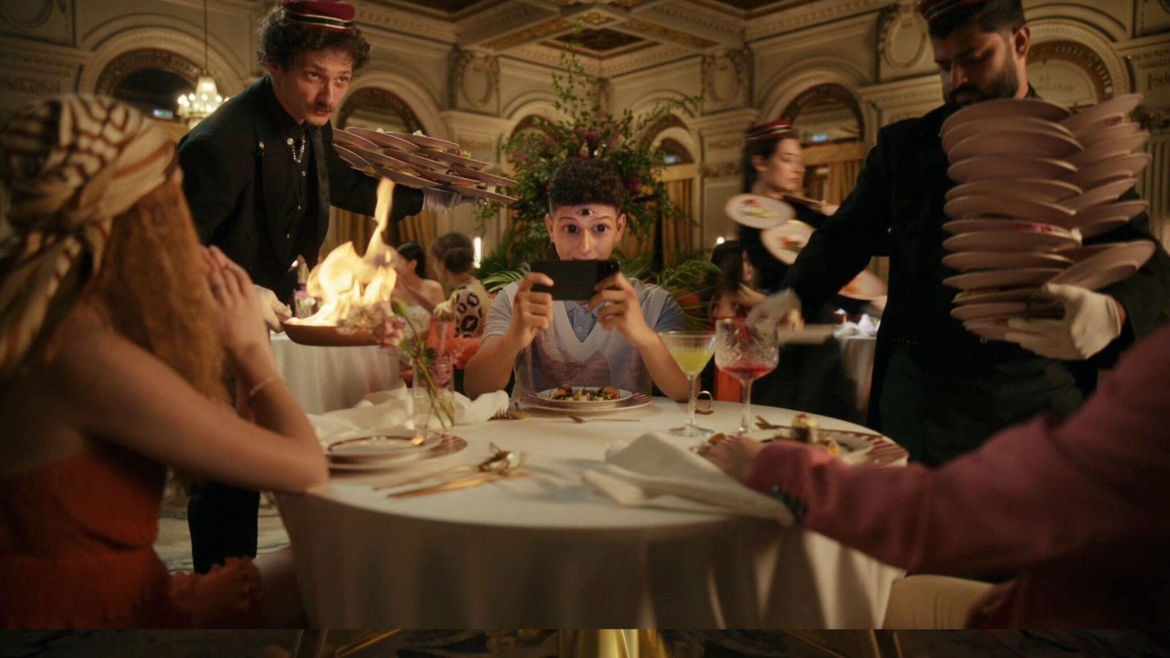Waiters presenting dishes to guests at a round restaurant table