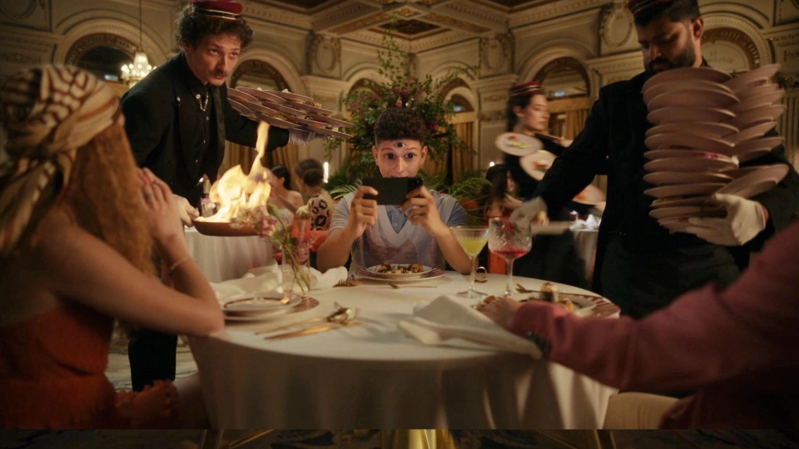 Waiters presenting dishes to guests at a round restaurant table