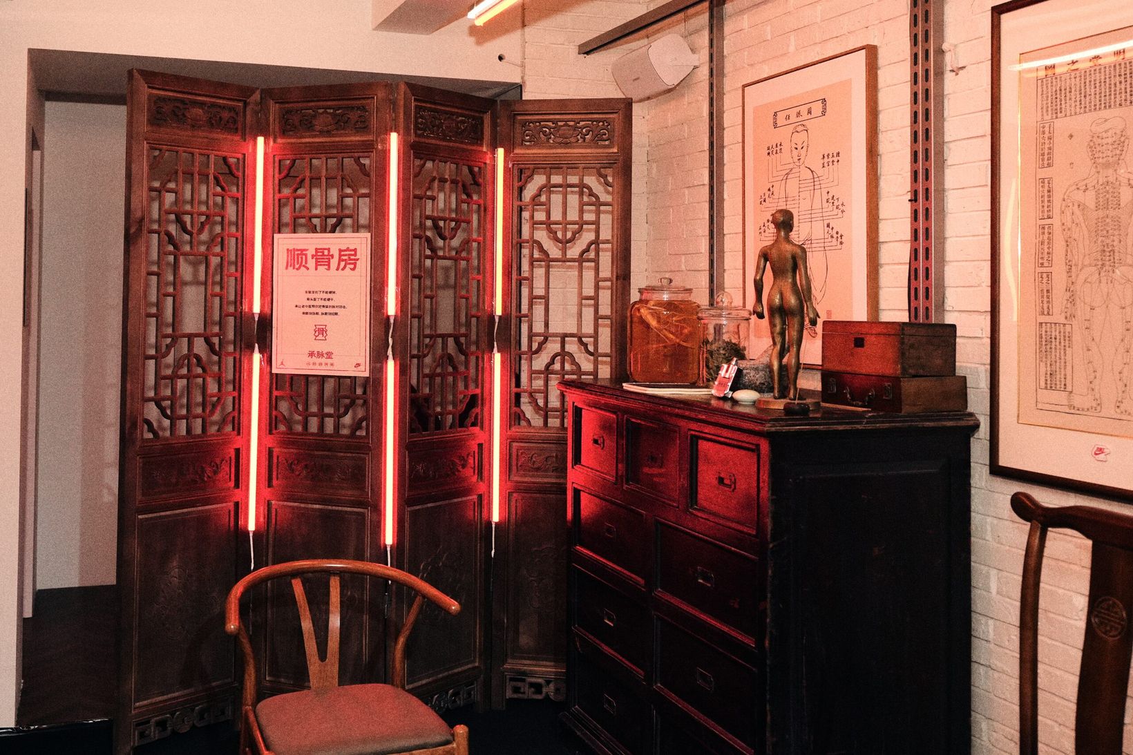 Osteopathy room with carved wooden screens and red neon lights