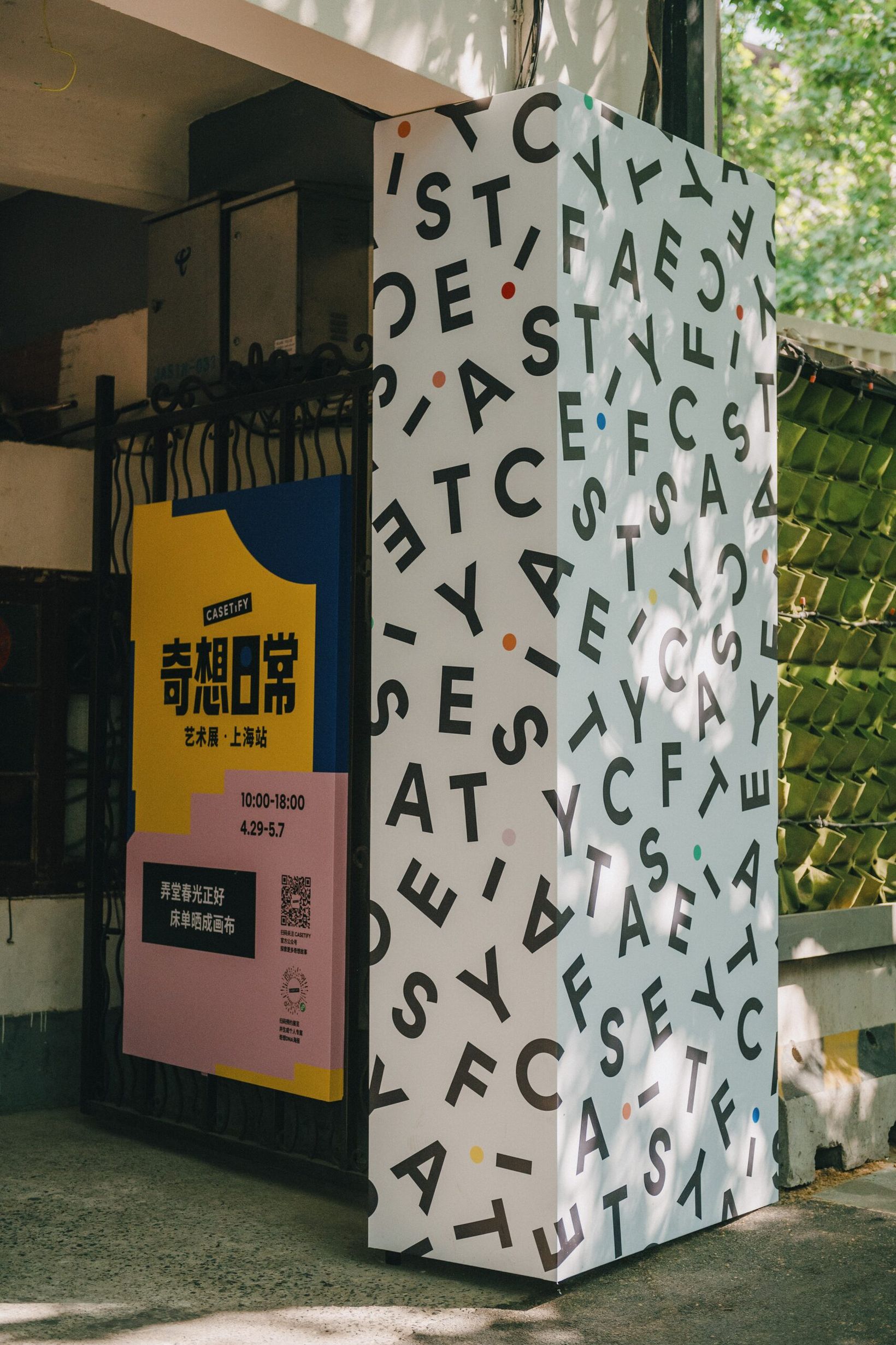 Exhibition entrance with campaign signage and a pillar printed with CASETiFY letters