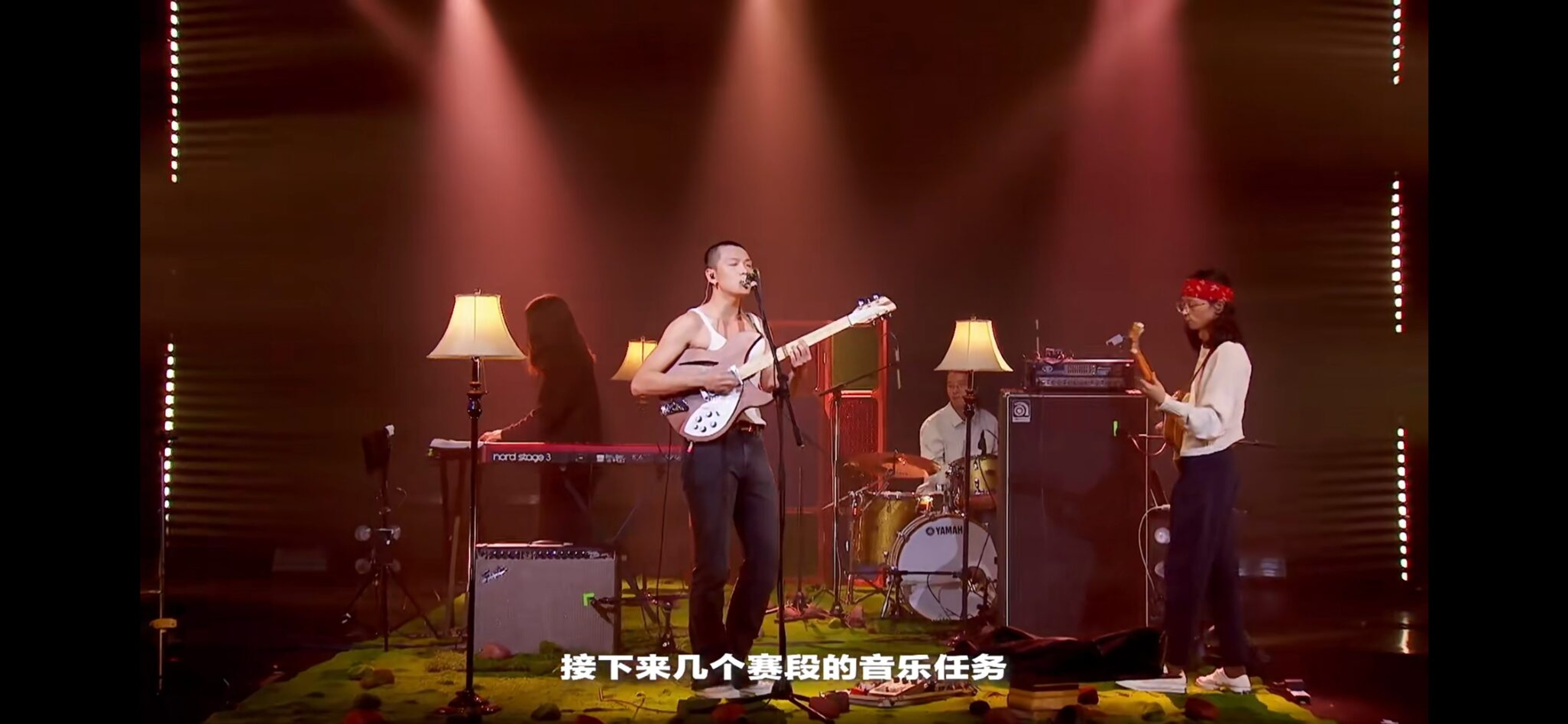 Musicians performing on stage under red light in the variety show