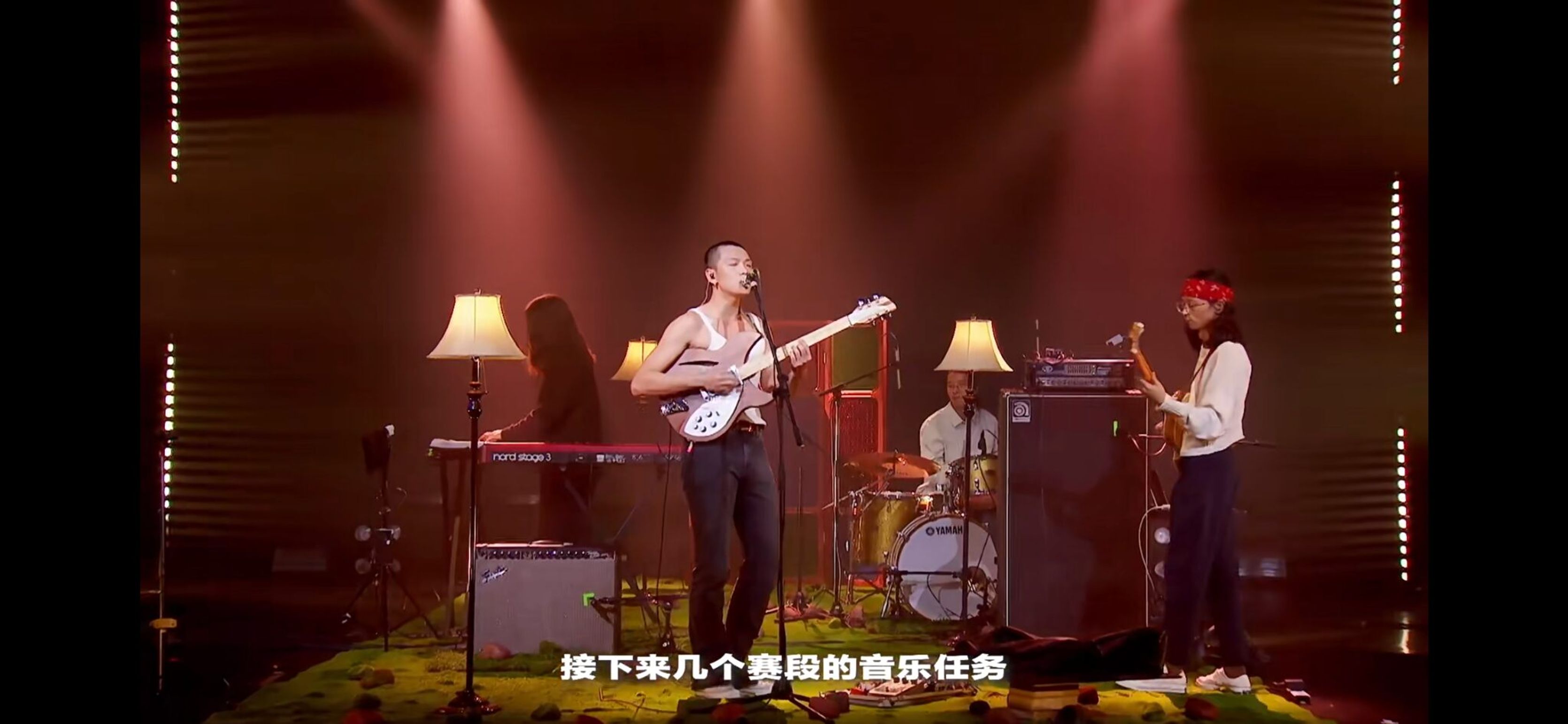 Musicians performing on stage under red light in the variety show
