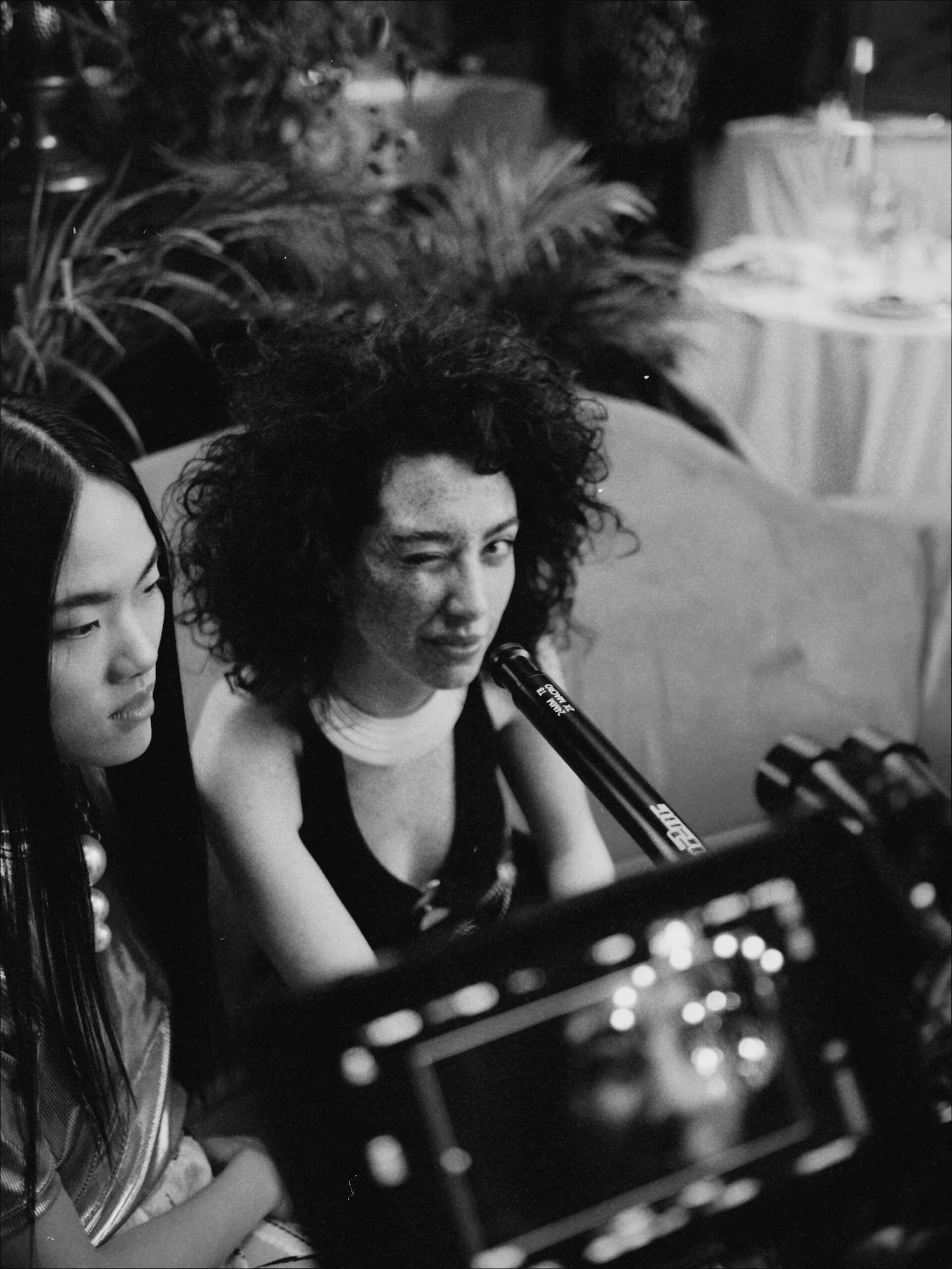 Black-and-white behind-the-scenes shot of crew watching a monitor
