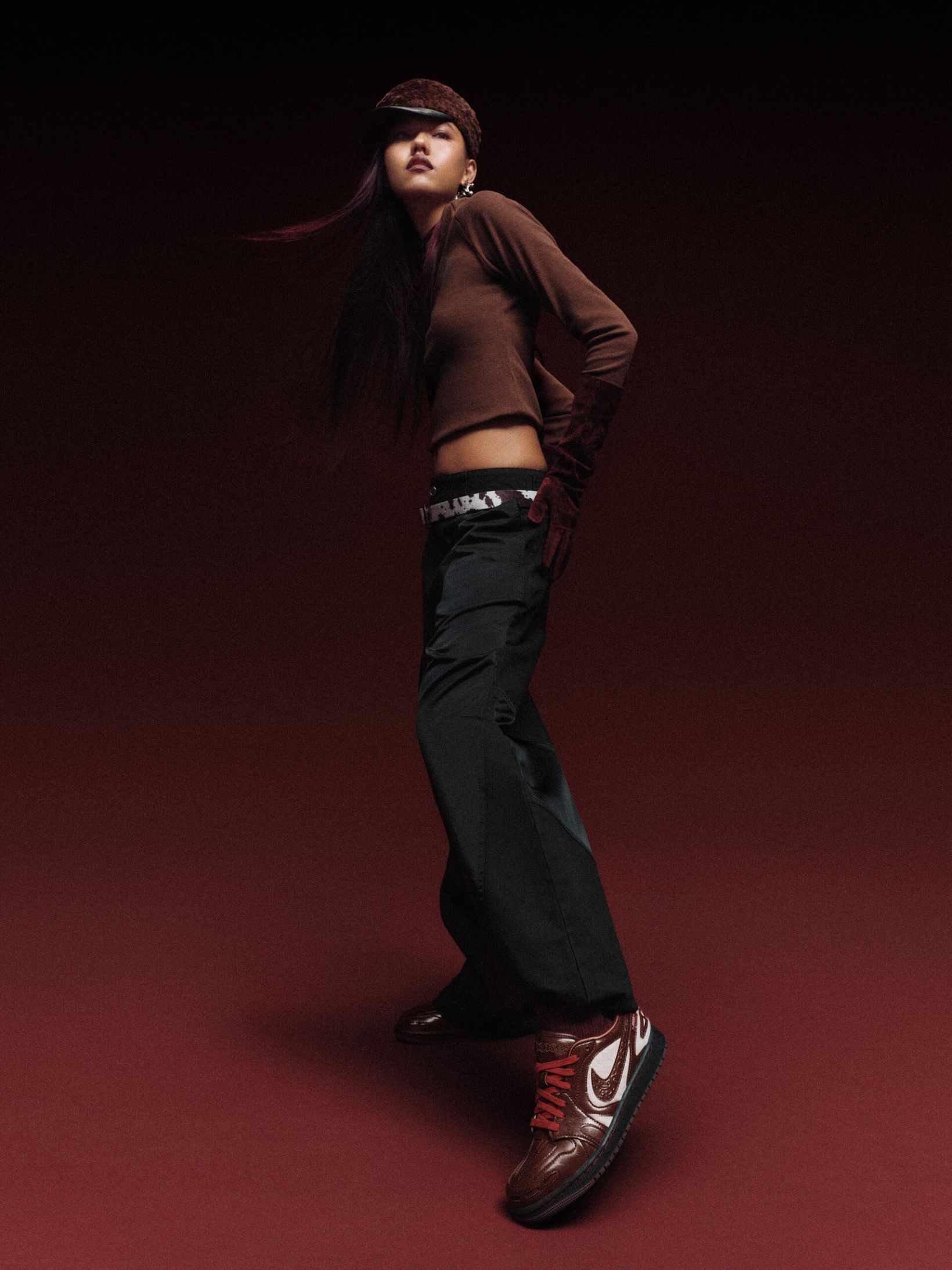 Model mid-stride in a brown jacket and Jordan sneakers